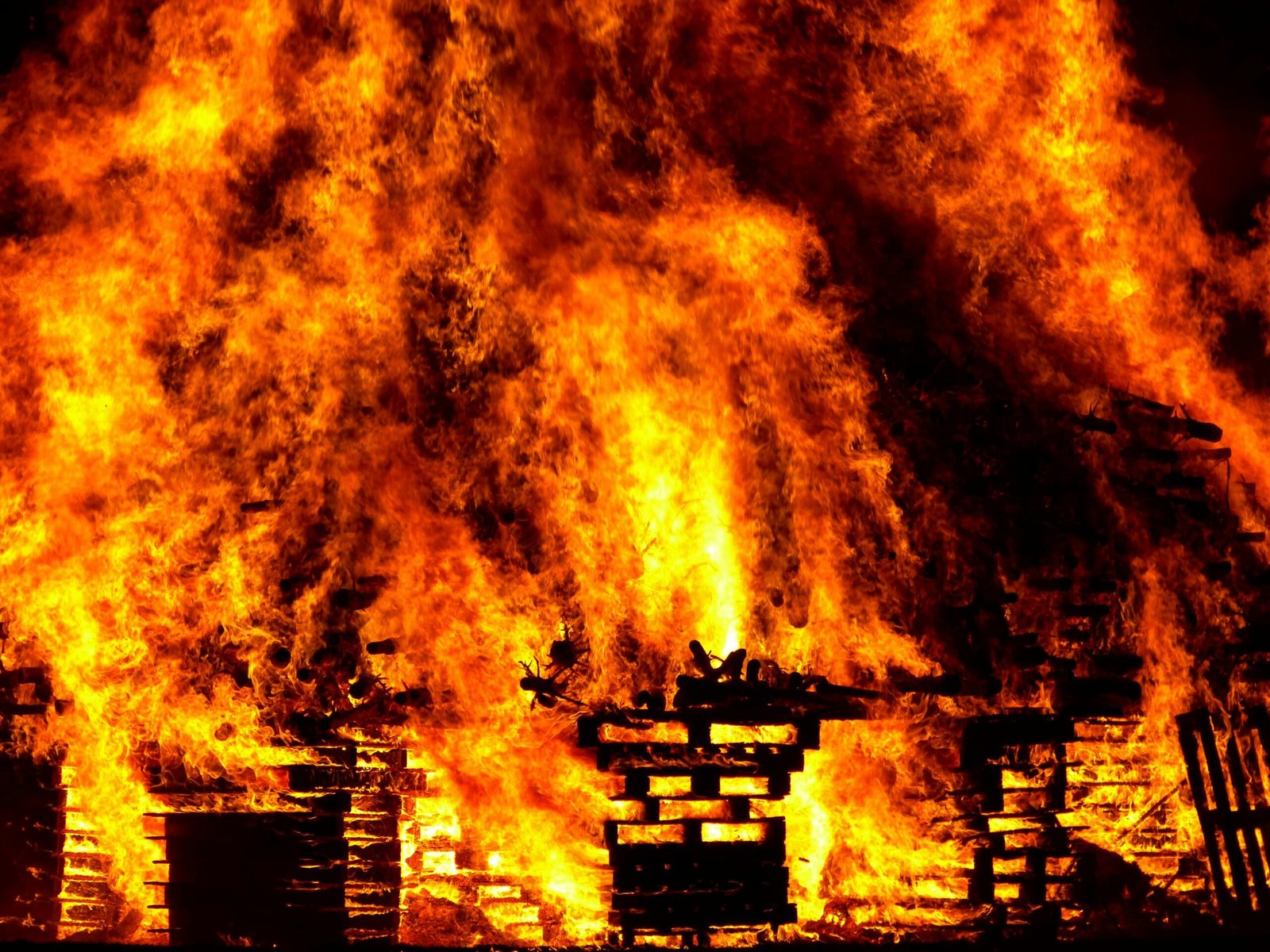 Intense flames engulf wooden pallets in a breathtaking display of fire and heat.